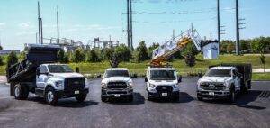 A lineup of rental trucks, including a dump truck rental, pickup truck rental, bucket truck rental with a two-person platform, and flatbed truck rental, showcasing the diverse fleet available at City Rent a Truck.