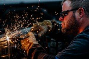 An upfit technician welding a truck for a custom upfit at City Rent a Truck, showcasing expert craftsmanship and attention to detail.